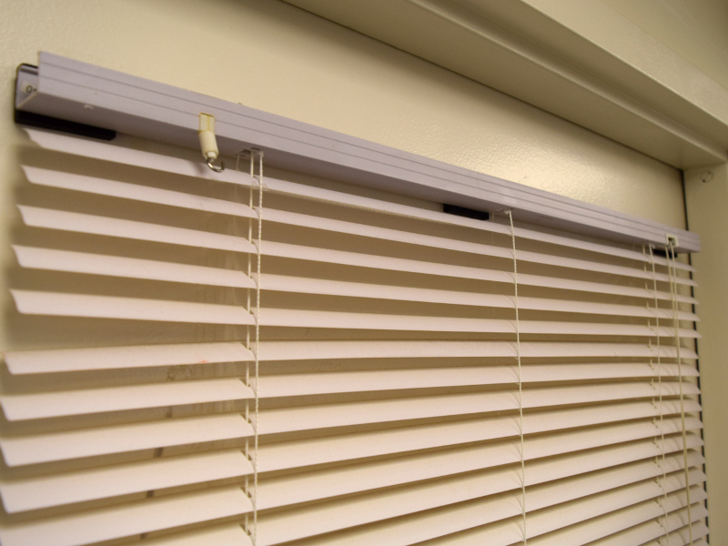 Rubber coated magnets holding blinds to door