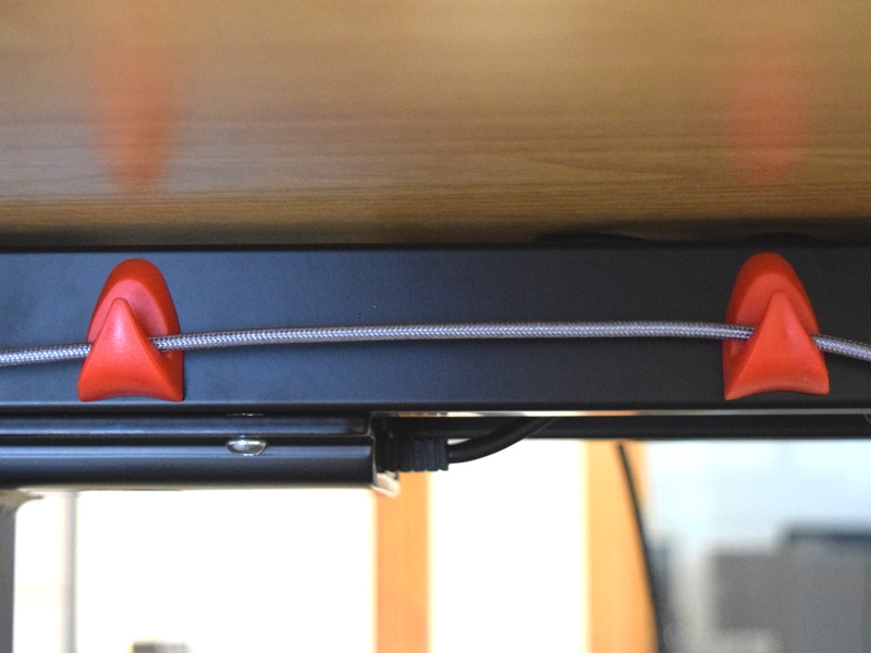 Picture of magnetic hooks holding up cords for organization