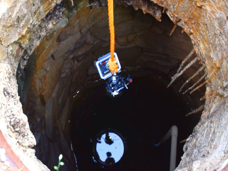 Dropping fishing magnet into well in hopes of finding treasure