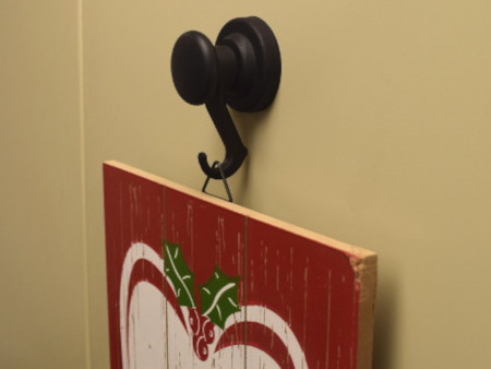 Neodymium hook magnet with rubber pad hanging a decoration on steel filing cabinet